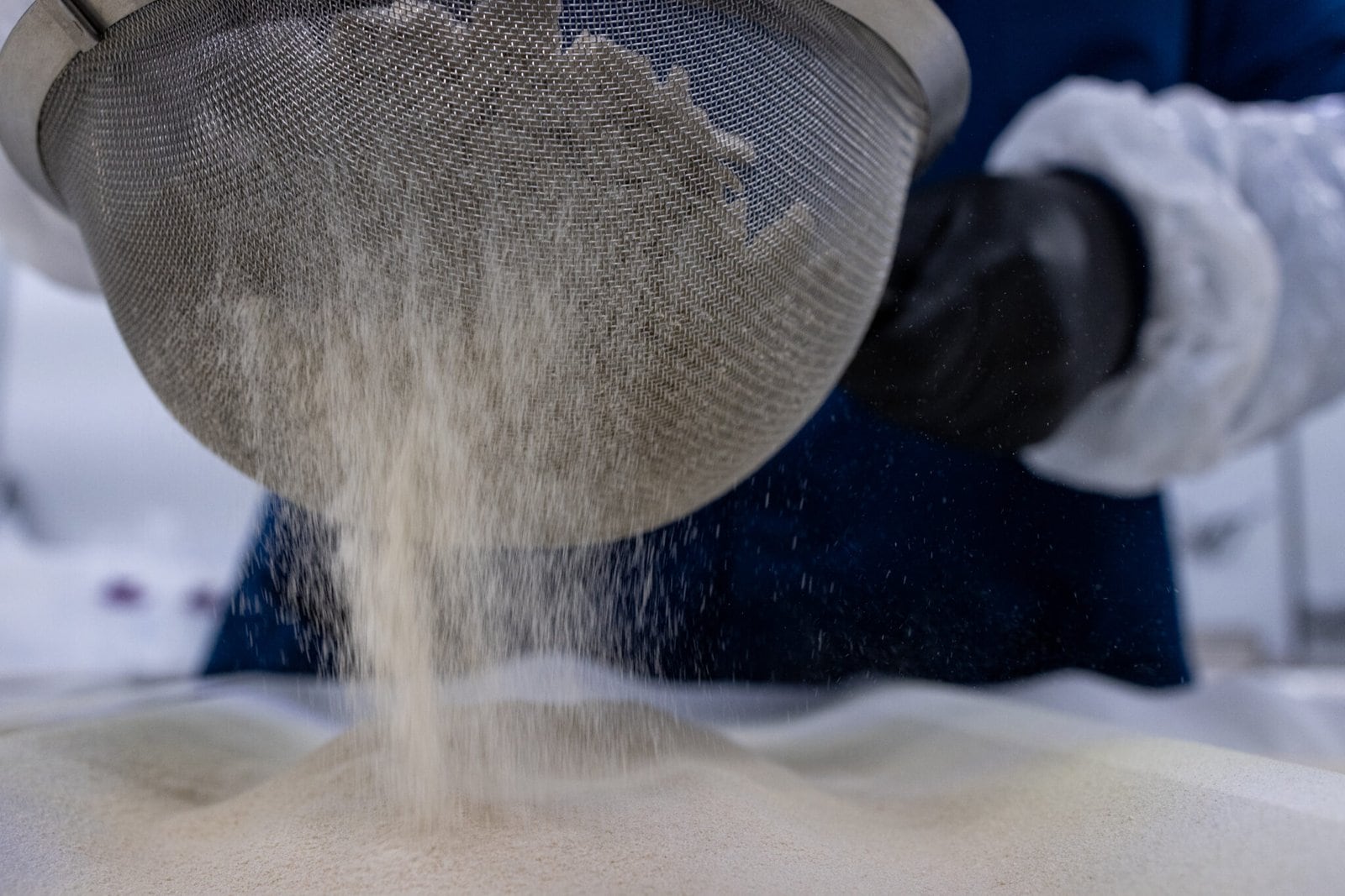 Cold hash being sieved on top baking tray inside cold room